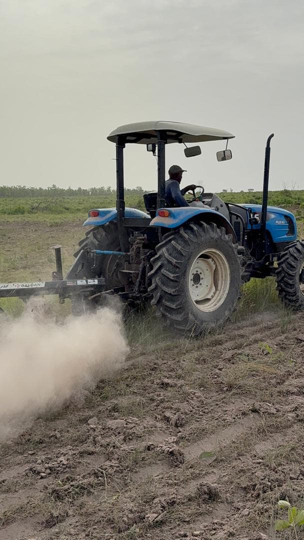 Tractor ploughing farmland during commercial farm expansion